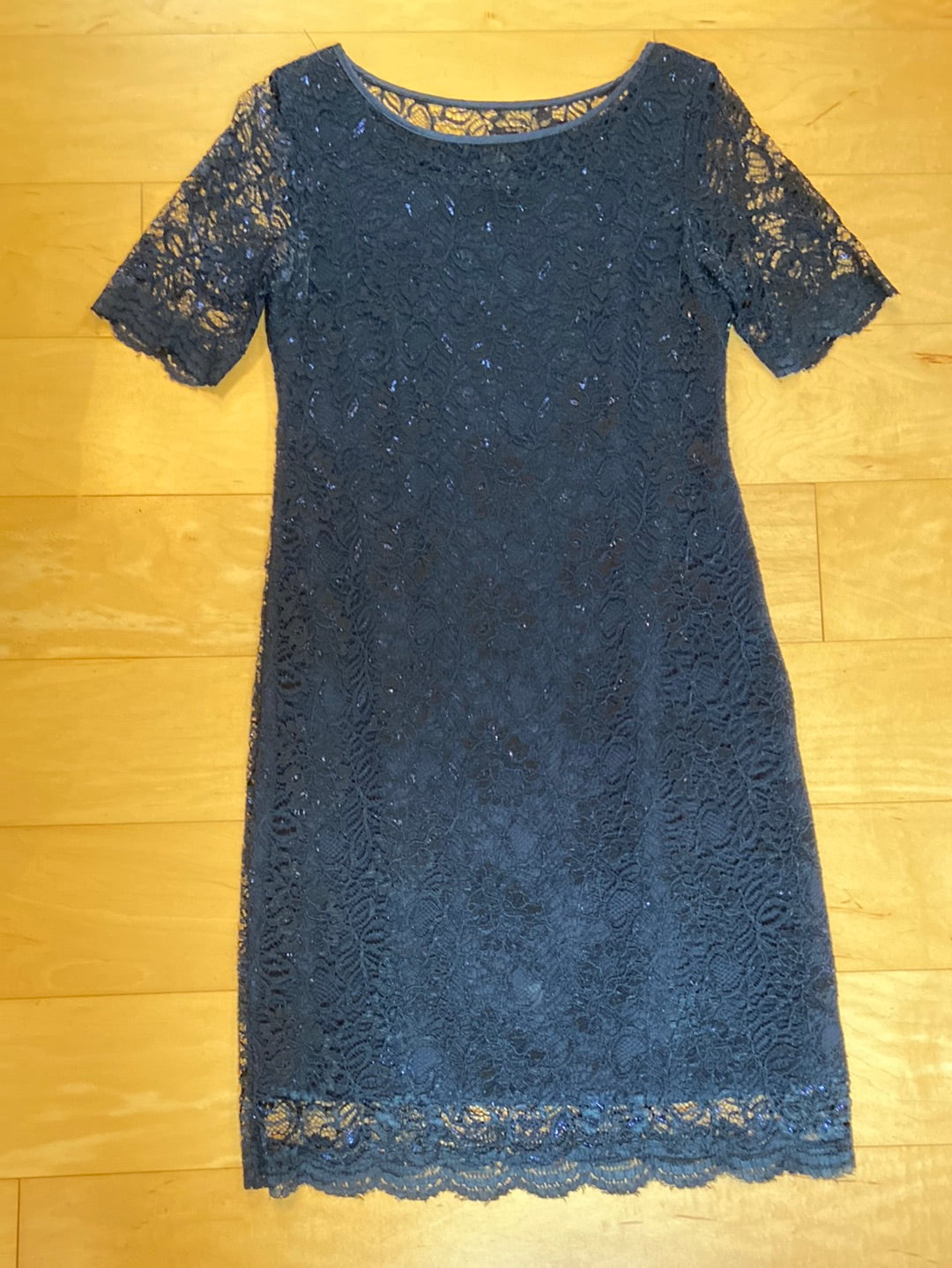 Navy blue short sleeve dress with rayon lace throughout the dress, knee length, crew neck, sheer sleeves