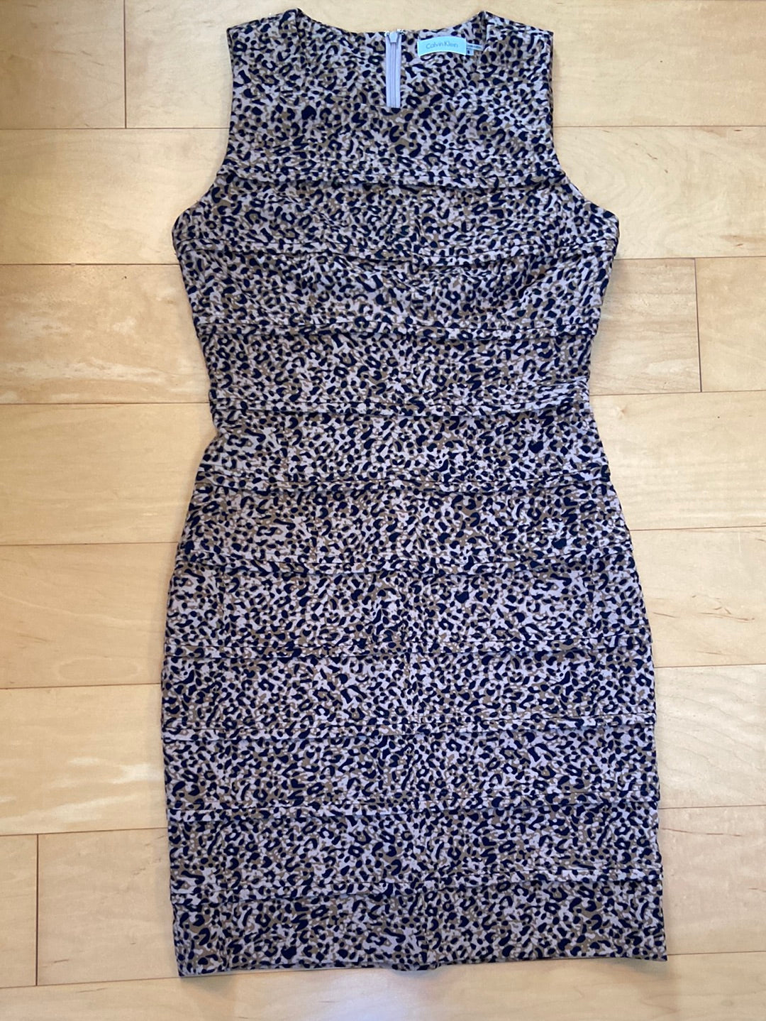 Sleeveless shift dress in brown and black animal print with tiered bodice and skirt knee length